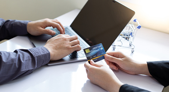 Both business people use laptop and phones to register online purchases using credit card payments, Convenience in the world of technology and the internet, Shopping online and banking online concept.