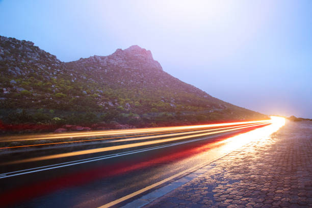 istock A Wet mountainside road with blurred light trails. 1227589780