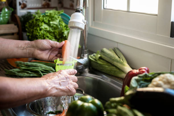 istock Woman's hands wash fresh vegetables under running water while peeling a carrot. Healthy lifestyles and vegan and vegetarian food concept 1227591570