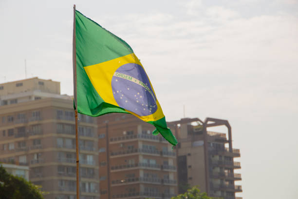 brazil flag outdoors with buildings in the background in Brazil.