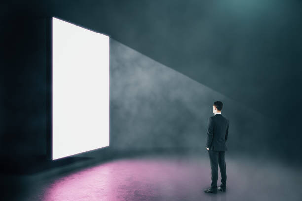 istock Businessman looking on blank glowing banner 1227591754