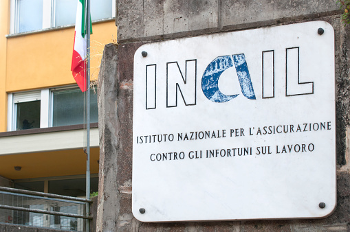 Carrara, Italy - May 28, 2020 - Marble plaque at the entrance of an Inail building (Italian National Institute for Insurance against Accidents at Work)