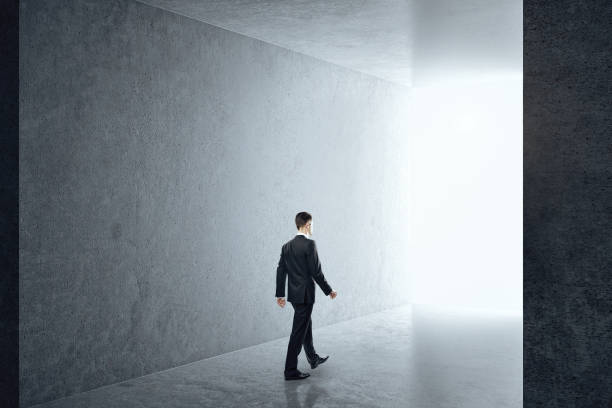 istock Businessman in interior with empty concrete wall 1227593175