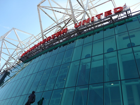The east stand of Old Trafford football stadium, home of Manchester United. With space for 75,957 spectators, Old Trafford has the second-largest capacity of any English football stadium after Wembley Stadium. Old Trafford Stadium of Manchester United England football club. The stadium is now empty because of the COVID-19 disease