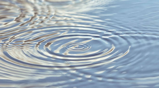 Photo of Round droplets of water over the circles on the water. Ripples on sea texture. Closeup water rings