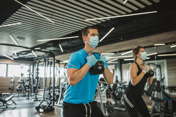 training im fitnessstudio nach pandemie - abstand halten infektionsvermeidung fotos stock-fotos und bilder