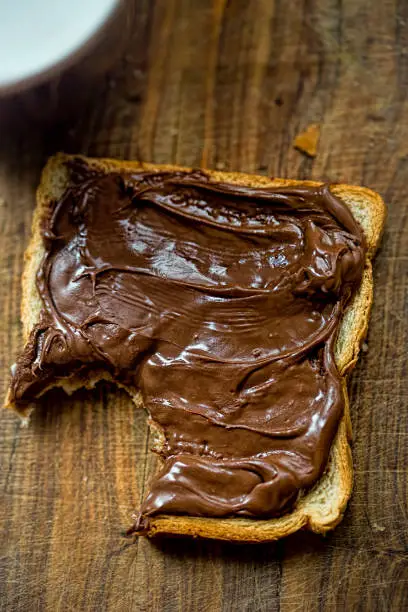 Toast with nutella spread on wooden board