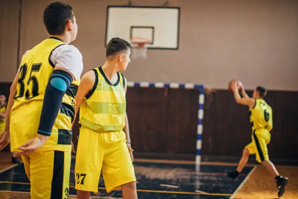 Group of men, teenage boys basketball players on training indoors.