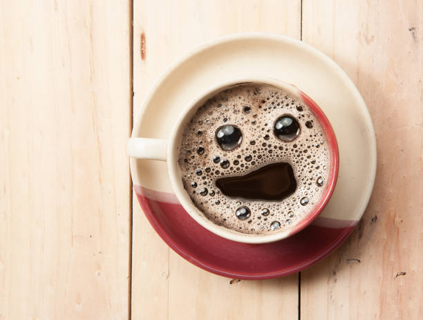 istock Espresso Cup with smiley face on wooden table, overhead view 1227599434