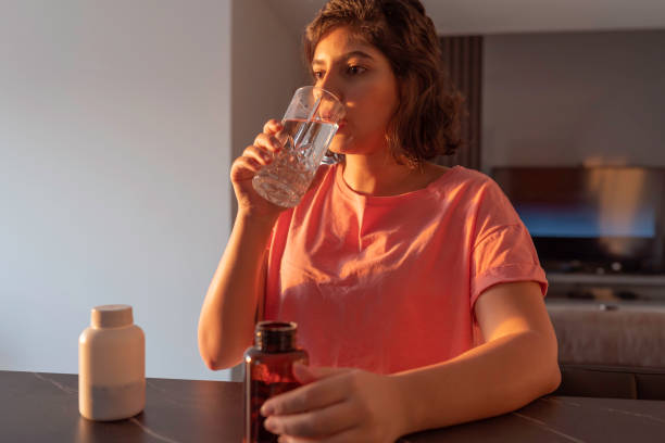 istock woman taking supplements at home 1227599549
