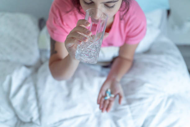 istock woman taking supplements at home 1227599644