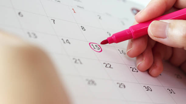 istock Hand with pen mark at 15th on calendar date 1227600659