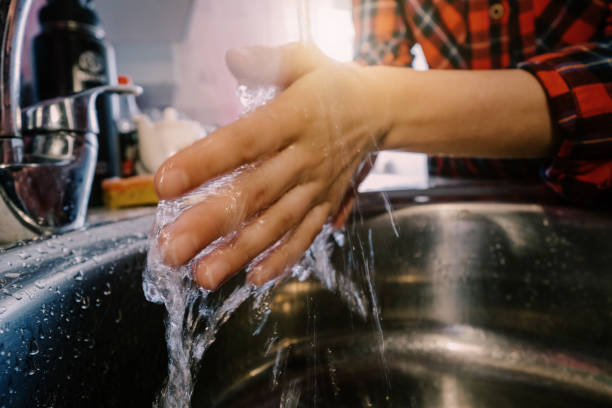 istock Female washing her hands in water under tap 1227600969