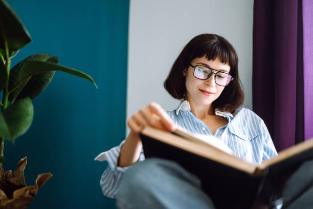 istock A young woman reads a book at home. 1227601255