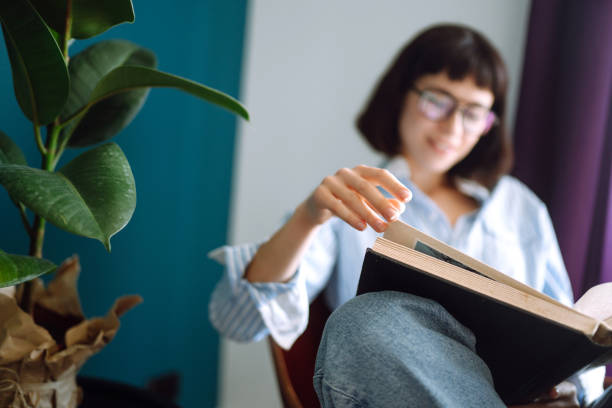 istock A young woman reads a book at home. 1227601283