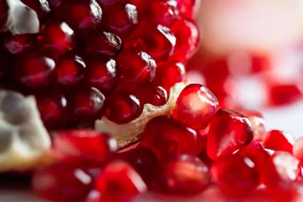 Macro image of red ripe pomegranate, shallow depth of field. Summer fruits background