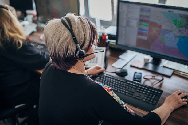 due donne operatore di servizio taxi con cuffie che lavorano nel call center - mittente foto e immagini stock