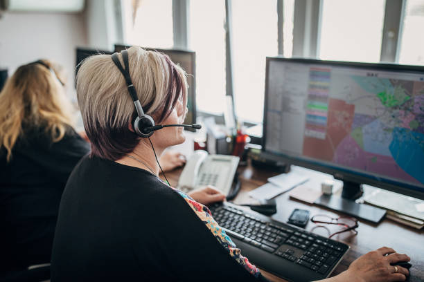 due donne operatore di servizio taxi con cuffie che lavorano nel call center - mittente foto e immagini stock