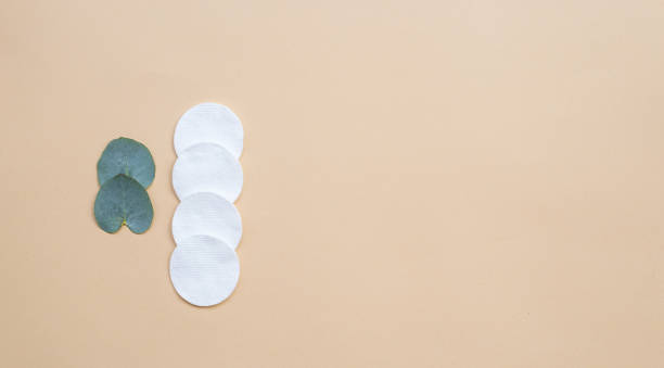 istock Cotton pads and fresh eucalyptus leaves on a beige background. Flat lay, top view, copy space. Women's health care 1227605716