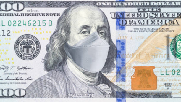 使い捨て医療マスク付き100ドル紙幣。米国におけるコロナウイルスの流行の概念。コロナウイルス大流行が米国経済に及ぼす影響 - over 100 ストックフォトと画像