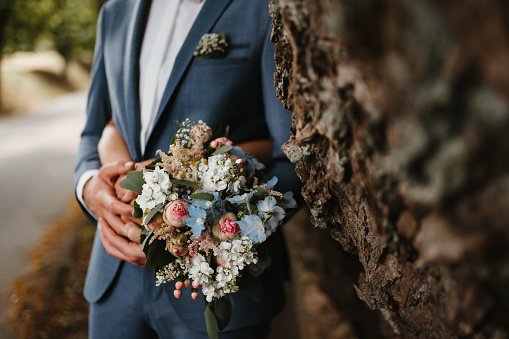 a groom and a bride holding a bouquet