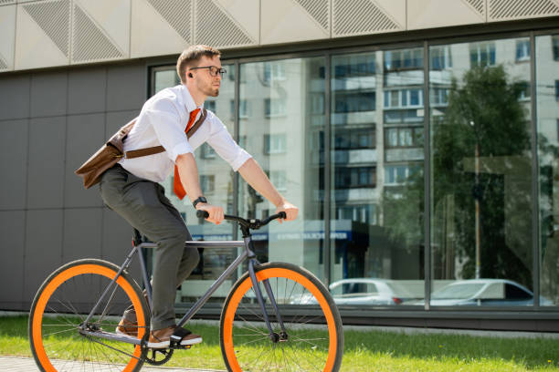istock Young businessman sitting on bicycle and moving to appointment with client 1227607135