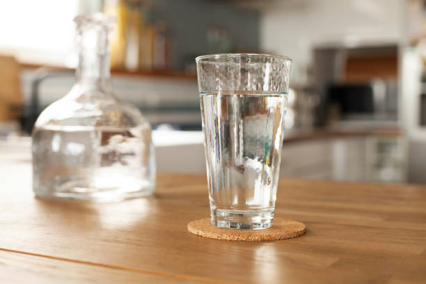 istock Glass of pure water and bottle on kitchen table 1227607466