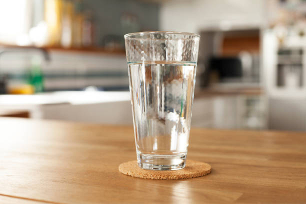 copo de água pura e garrafa na mesa da cozinha - water bottle purified water water drink - fotografias e filmes do acervo