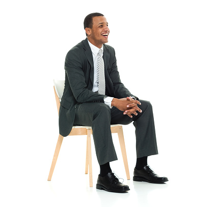 Side view of aged 20-29 years old african-american ethnicity young male business person resting in front of white background wearing businesswear who is happy