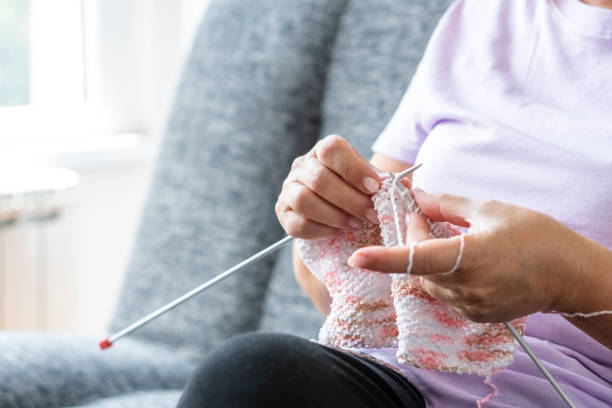 istock Senior woman knitting at home 1227609285