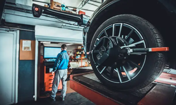 Photo of Wheel alignment equipment on a car wheel in a repair station