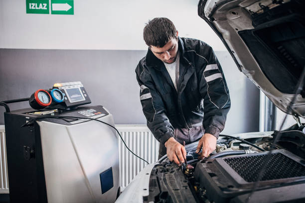 mecánico recargando el aire acondicionado del coche en el taller de reparación de automóviles - condensador componente eléctrico fotografías e imágenes de stock