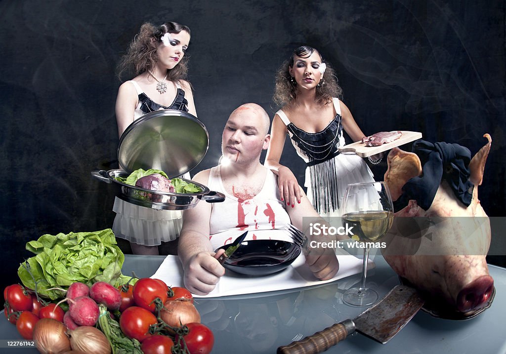 Ragazze con carne di maiale cruda di un uomo grasso - Foto stock royalty-free di Cena con invitati