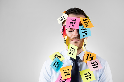 Office worker with post-its all over his face with find a job message