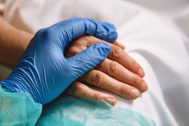 Healthcare worker giving support and love to a patient Close up of a doctor hand with blue glove giving support and love to a patient at hospital. Coronavirus pandemic concept. protective glove photos stock pictures, royalty-free photos & images