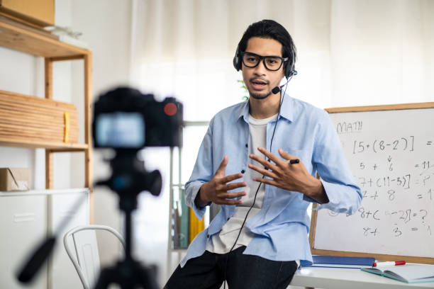 Asian school male teacher working from home teaching online math subject to student studying from home. Man using camera to record his live in internet. Remote education class during covid19 pandemic.