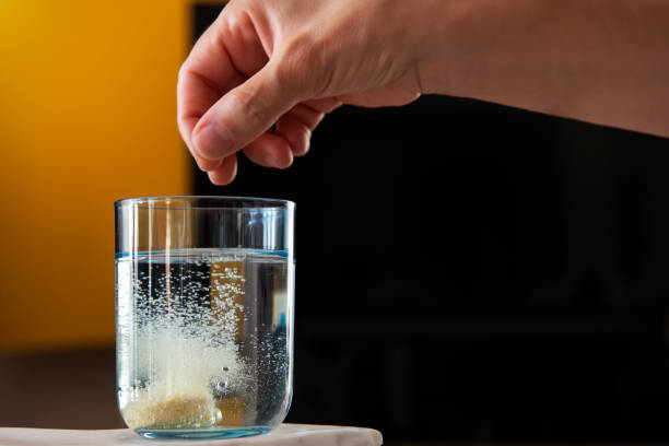 woman throws effervescent tablet in water