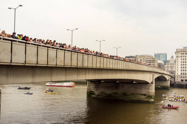 толпы людей на лондонском мосту наблюдают за речным шествием - olympic torch стоковые фото и изображения