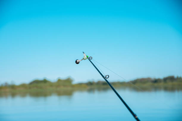 istock Fishing rod with bell end, blue sky, river 1227621387