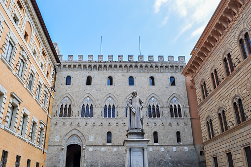 Siena, Italy - May 2019: Sallustio Bandini monument on Piazza Salimbeni square