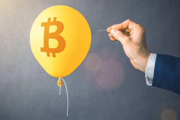 Bitcoin cryptocurrency symbol on yellow balloon. Man hold needle directed to air balloon. Concept of finance risk stock photo