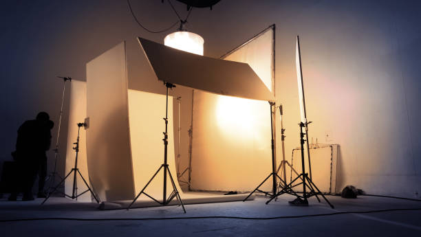 istock Shooting studio for photographer and creative art director with production crew team setting up lighting flash and LED headlight on tripod and professional equipment for portrait model photo shoot and video online filming 1227622051