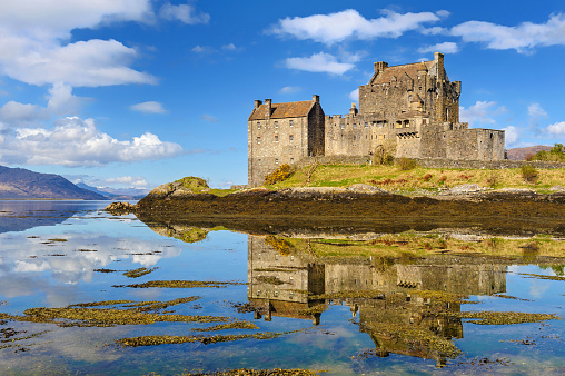Eilean Donan Castle, Scotland, UK - 18th April 2012: Wide angle view of Eilean Donan Castle during a sunny day. This iconic castle is on a small island where the three lochs of Loch Alsh, Loch Long and Loch Duich all meet.