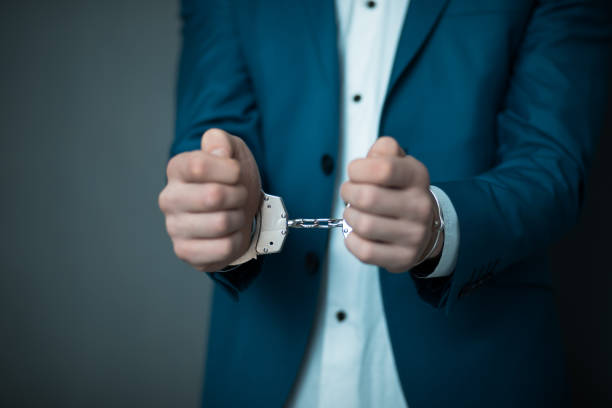 man hand handcuffs man hand handcuffs on gray background white collar crime handcuffs stock pictures, royalty-free photos & images