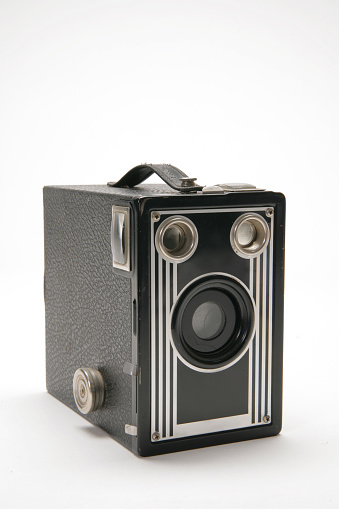Small black vintage black and silver box camera , isolated on white background. Photographed in the studio