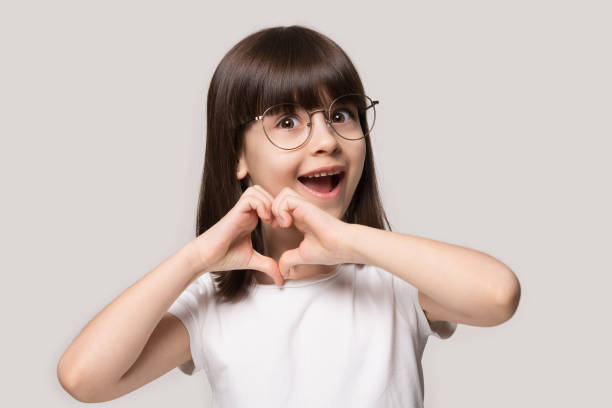 흥분 유치원 작은 사랑스러운 소녀 안경에, 사랑 기호를 보여주는. - glass heart 뉴스 사진 이미지