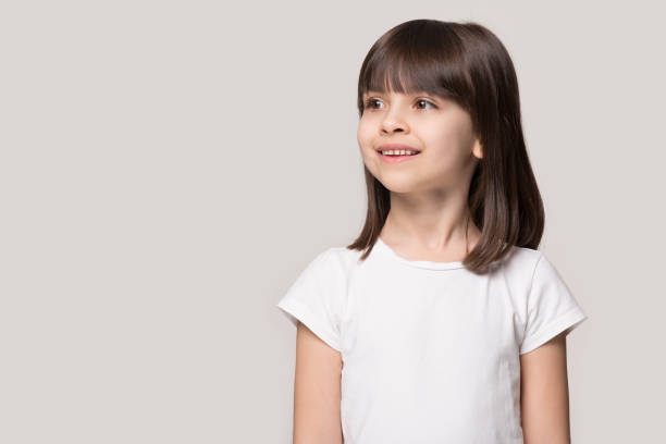 istock Happy brown-haired cutie standing near blank empty copy space. 1227629255