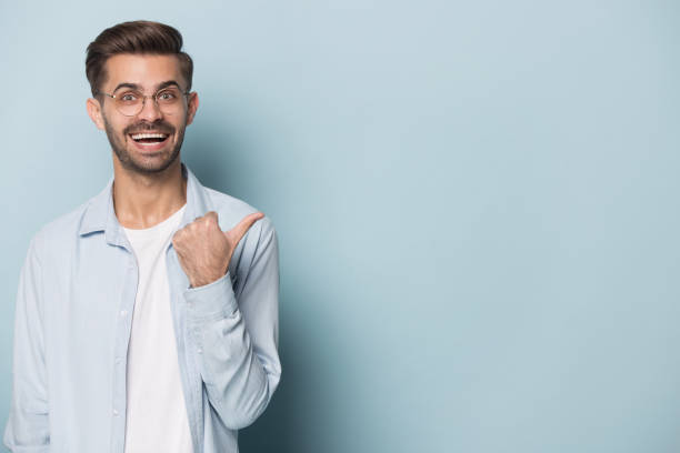 istock Happy surprised young man showing empty copy space. 1227629282