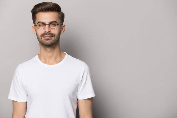 istock Suspicious young man wearing eyeglasses looking aside on copy space. 1227629317