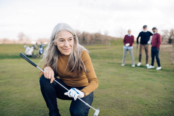 Portrait of a senior woman  who took a golf shot Senior woman playing golf with her friends. golf concentration stock pictures, royalty-free photos & images
